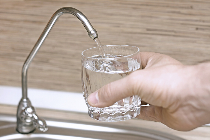 countertop water filter pouring water into glass